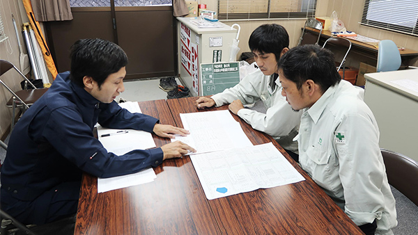 測量士が建設会社の現場監督とICT施工計画を打ち合わせている様子